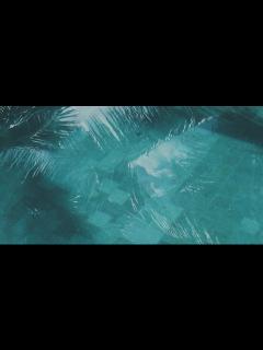 [画像][x]水着姿の女性がプールに足を浸している：無料の動画素材 余白なし